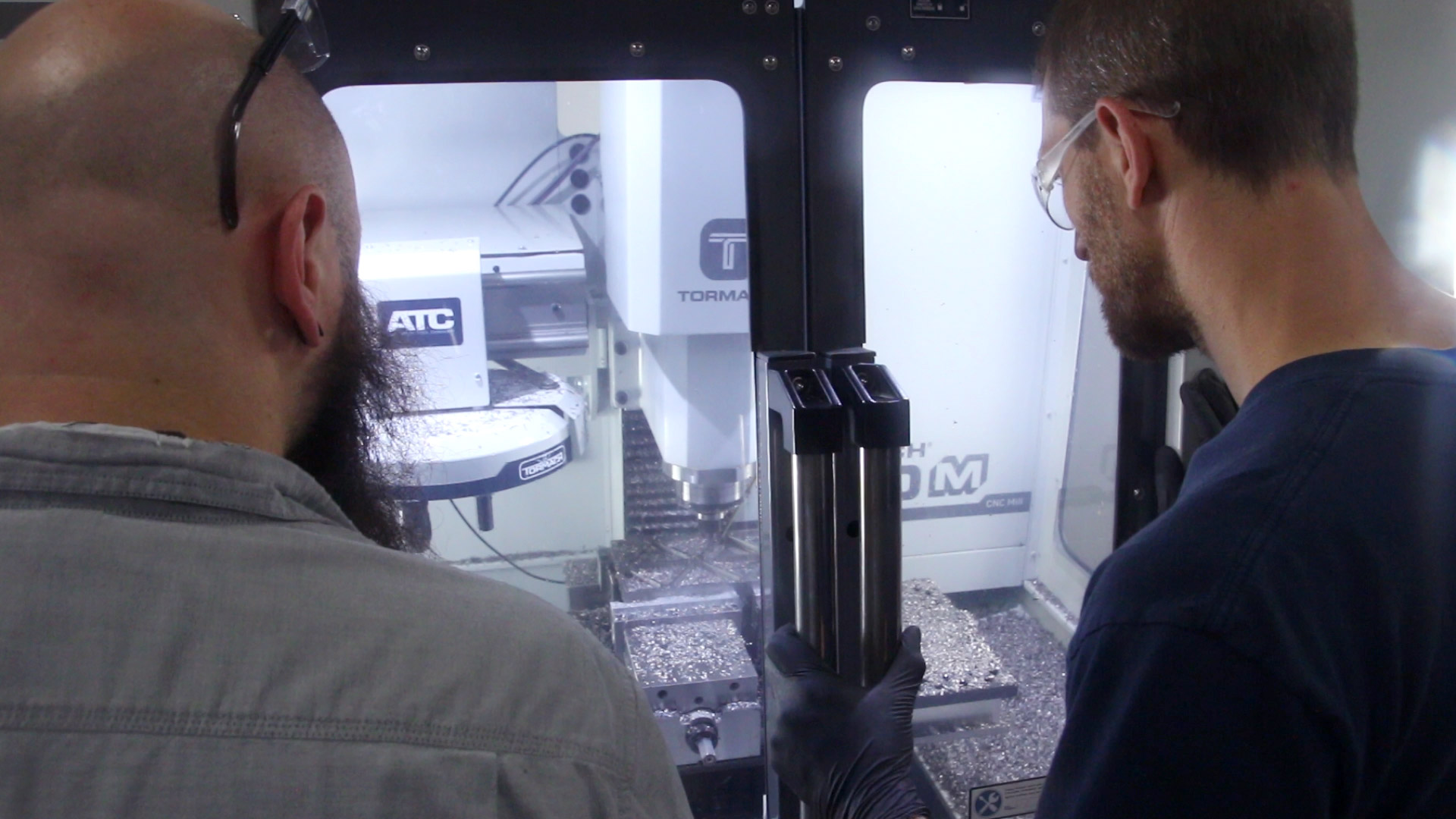 Technician performing on-site service on a Tormach mill
